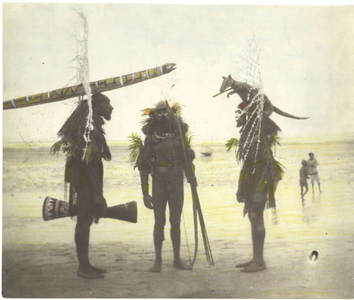 229024 Drie mannen van de Marind-anim, waarvan twee als dema, op het strand nabij Okaba (Indonesië)